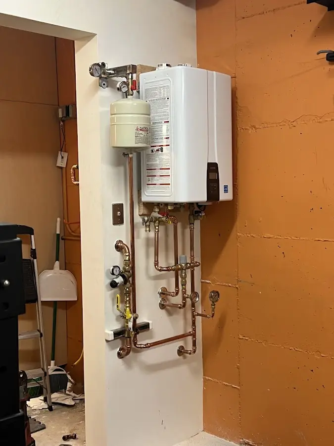 Plumbing technician inspecting water heater connections in Cashmere